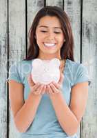 Woman with piggy pank against wood panel