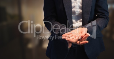 Business woman mid section holding out hands in blurry room