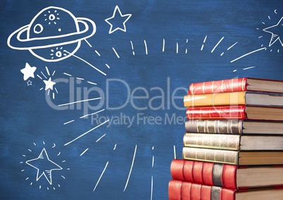 Pile of books with space doodles against blue chalkboard