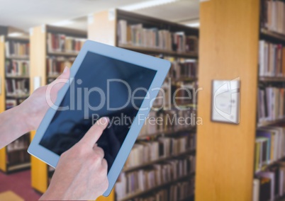 Womans hands touching tablet in Library