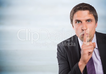 Business man finger over mouth against grey wood panel