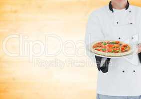 Chef with pizza against blurry yellow wood panel