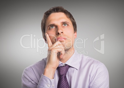 Man in lavender shirt thinking against grey background