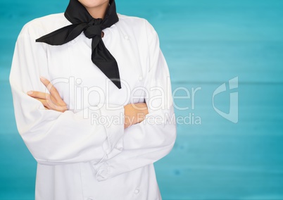 Chef arms folded against blurry blue wood panel