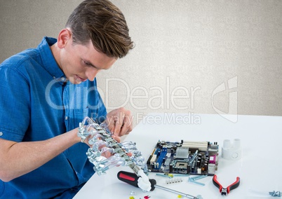 Man with electronics against grey wall
