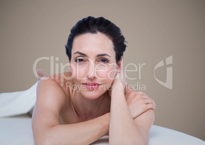 Woman lying on front against brown background