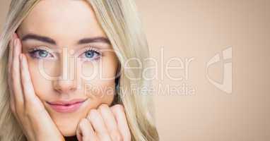 Close up of woman with hand on face against cream background