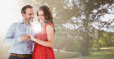 Couple engaged in park with bright light and flare