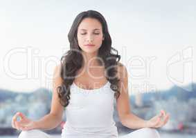 Woman meditating by hills