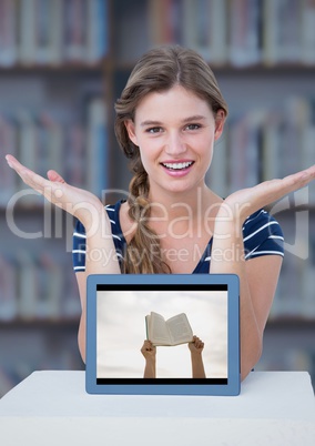 Woman at table with tablet showing hands with book against blurry bookshelf with blue overlay