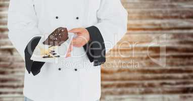 Chef with cake against blurry wood panel