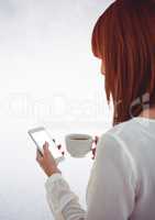 Woman with coffee and phone against white wall