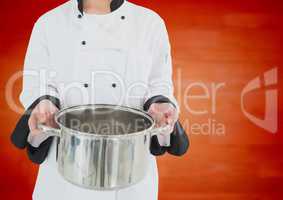 Chef with saucepan against blurry orange wood panel