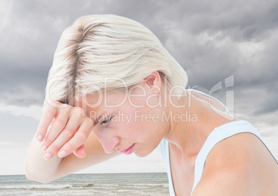 Sad tired woman against cloudy sky and ocean