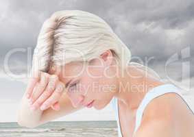 Sad tired woman against cloudy sky and ocean