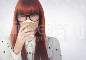 Close up of woman with coffee cup over face against white wall