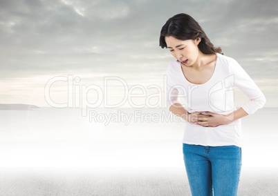 Woman holding tummy pain in front of clouds