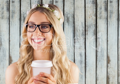 Woman with flowers in hair and coffee cup against wood panel