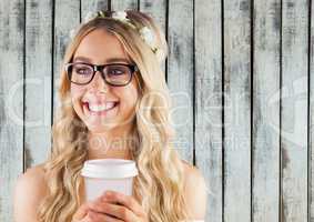Woman with flowers in hair and coffee cup against wood panel