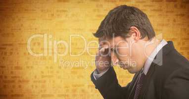 Portrait of business man hand on forehead against yellow brick wall