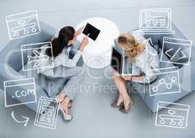 Top down view of two business women with white business doodles