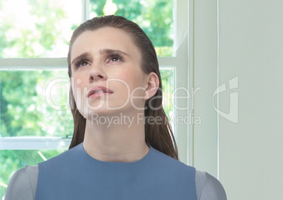 Worried women looking up for hope against sunny window