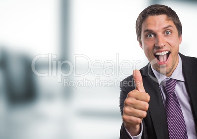 Business man thumbs up against blurry office