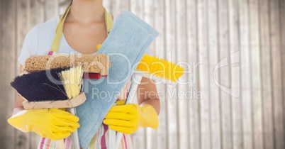 Woman in apron with brushes against blurry wood panel