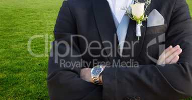 Groom mid section with arms folded against grass