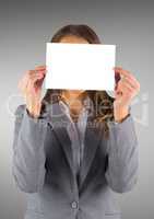 Business woman with blank card over face against grey background