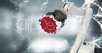 White robot claw with red cog and white interface against blurry grey room