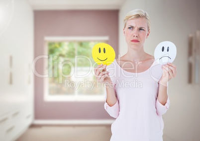 Women holding faces deciding happy or sad emotions against room