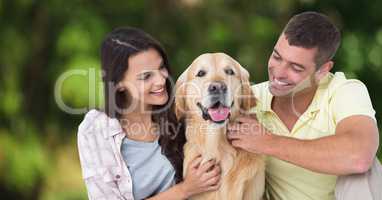 Couple with dog against blurry green background