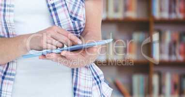 Womans hands touching tablet in Library
