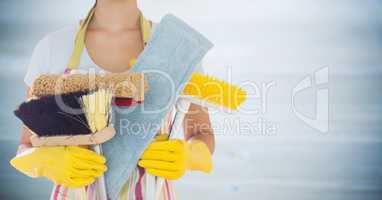 Woman in apron with brushes against blurry grey wood panel