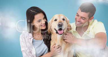 Couple with dog against blue background with clouds