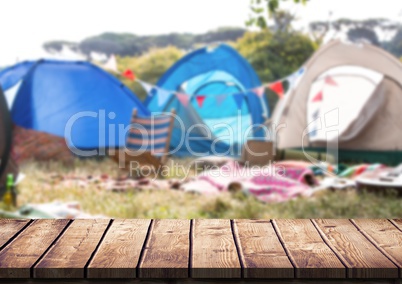 Wood table against blurry campsite