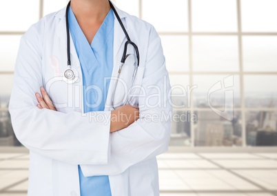 Doctor mid section with arms folded against blurry window