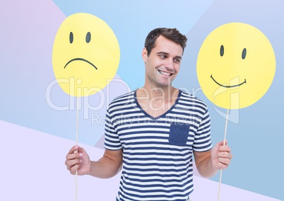 Man holding happy and sad face against blue background