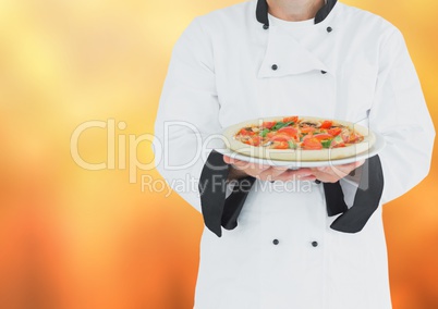 Chef with pizza against blurry orange background