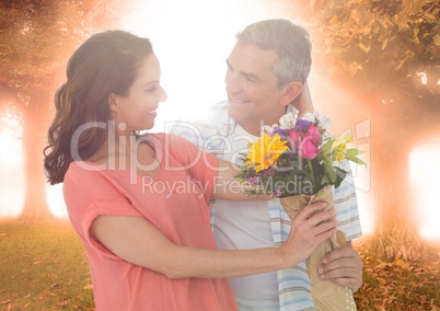 Couple with flowers against trees and flares