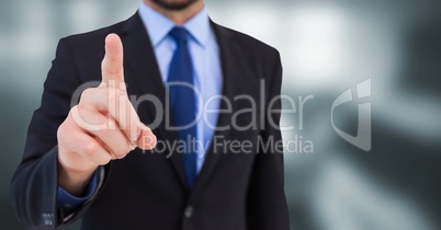 Business man mid section pointing in blurry grey room