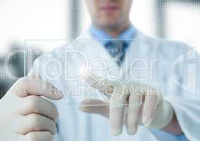 Man in lab coat pointing at white interface and flare on glass device against blurry window
