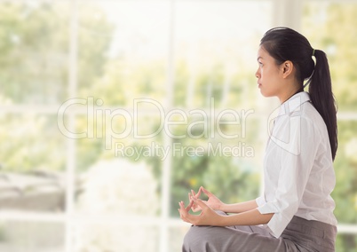 Woman Meditating by windows