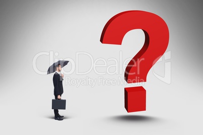 Confused businessman standing in front gigantic 3d question mark