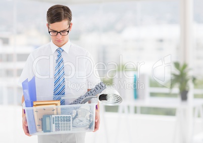 Businessman redundant with belongings in box in office