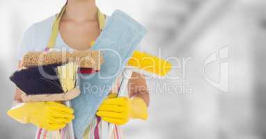 Woman in apron with brushes against blurry grey room