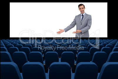 Businessman on screen presenting at blank  in front of 3d empty chairs