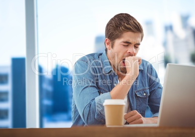 Man with laptop and coffee against blurry blue skyline