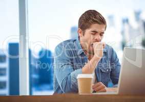 Man with laptop and coffee against blurry blue skyline
